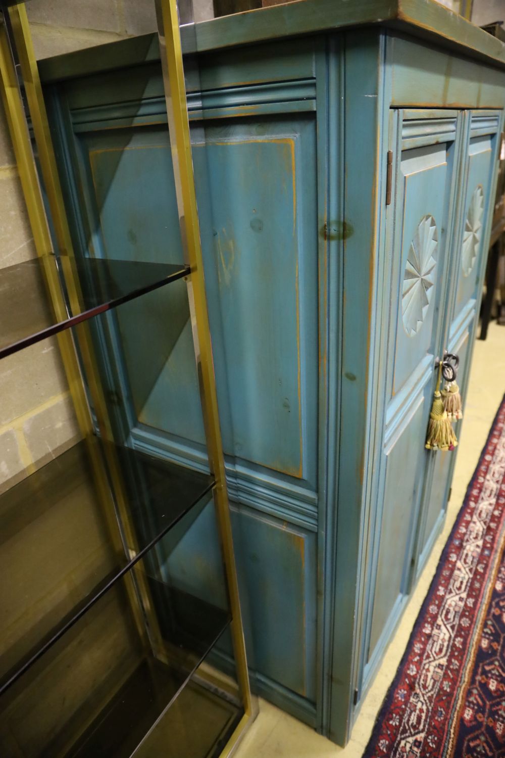 A distressed carved and blue-painted pine double wardrobe, width 96cm